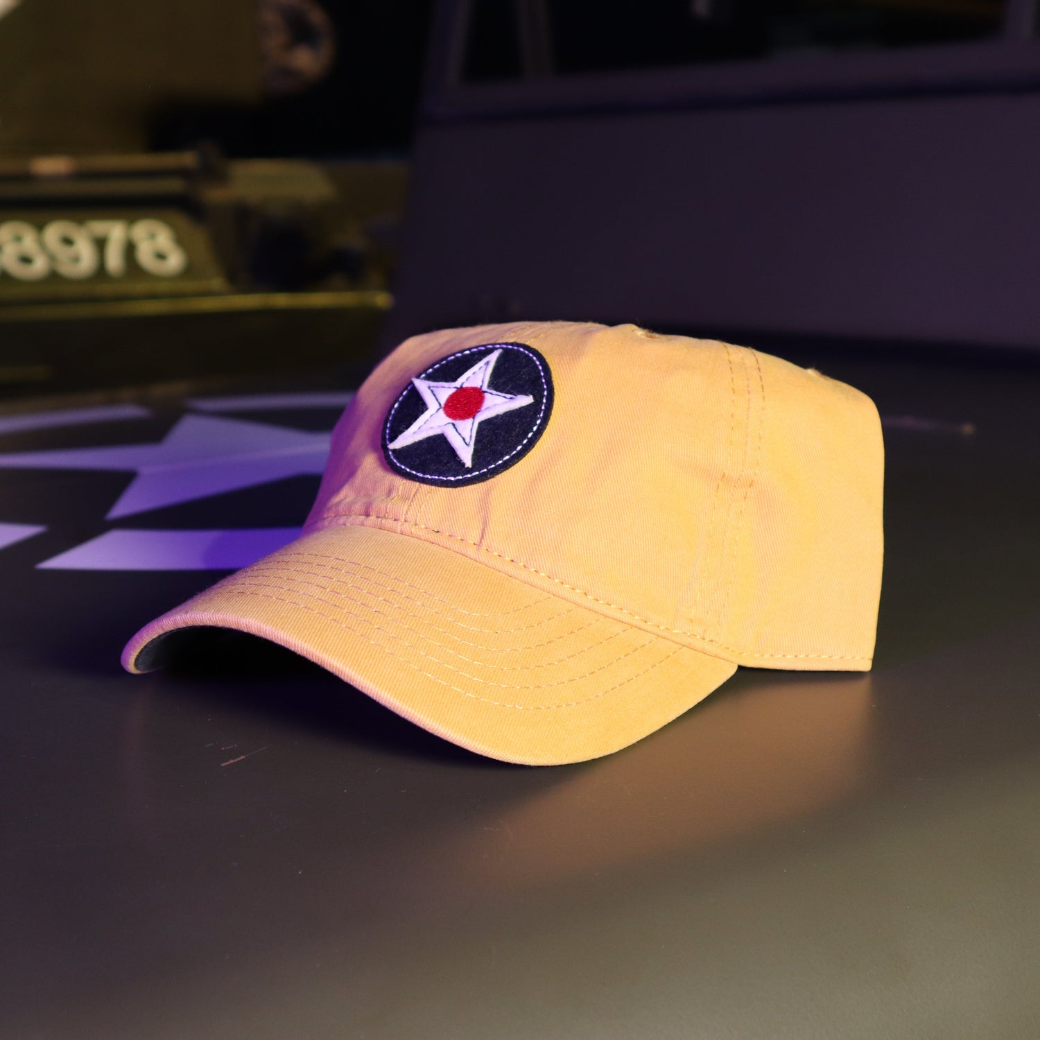 Yellow cap with a star emblem on a dark surface